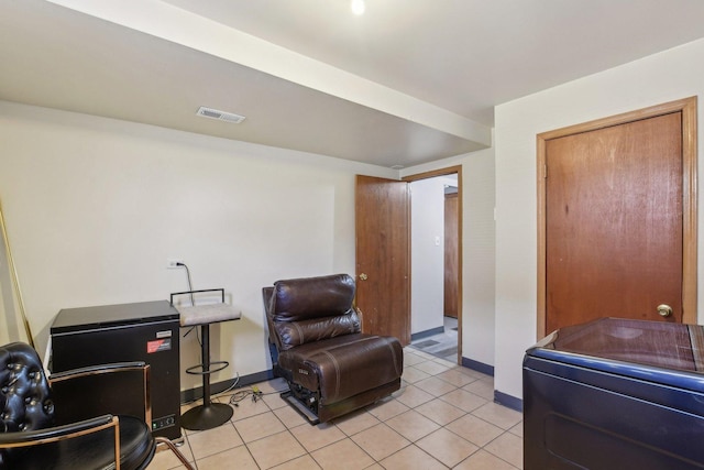 sitting room featuring light tile patterned floors, baseboards, and visible vents