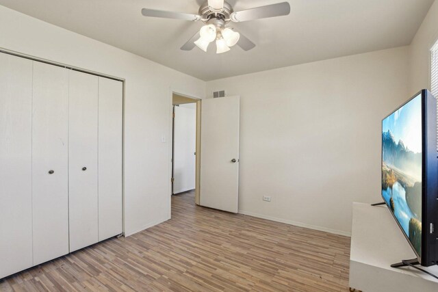 unfurnished bedroom with visible vents, a closet, light wood finished floors, baseboards, and ceiling fan