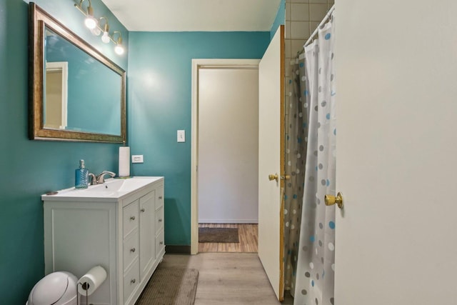 bathroom with baseboards, toilet, a shower with shower curtain, wood finished floors, and vanity