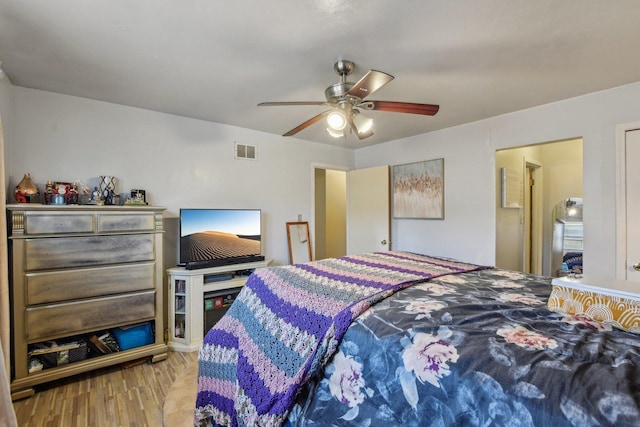 bedroom with visible vents, wood finished floors, and a ceiling fan