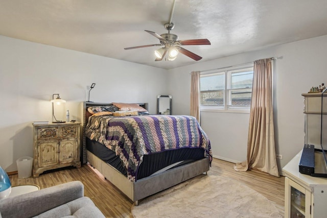 bedroom featuring a ceiling fan, wood finished floors, and baseboards