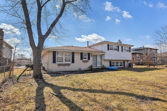 view of front facade with a front yard, cooling unit, fence, a chimney, and brick siding