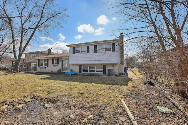 back of property featuring central air condition unit, a yard, brick siding, and a chimney