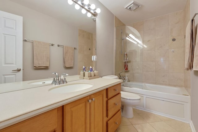 full bathroom featuring tile patterned flooring, tiled shower / bath, vanity, and toilet