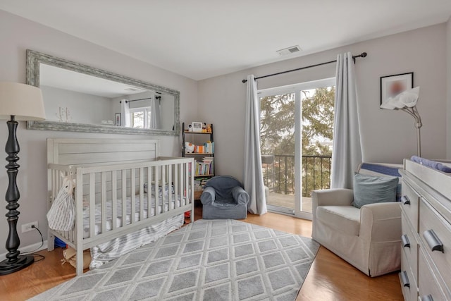 bedroom with access to exterior and light hardwood / wood-style floors