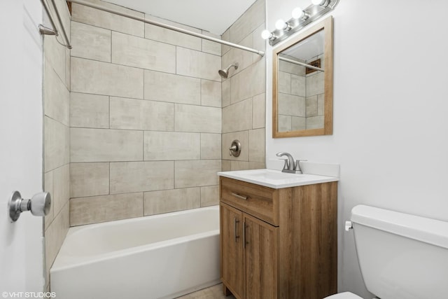 full bathroom with vanity, tiled shower / bath, and toilet