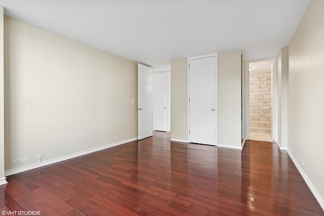 unfurnished bedroom with dark hardwood / wood-style floors and ensuite bathroom