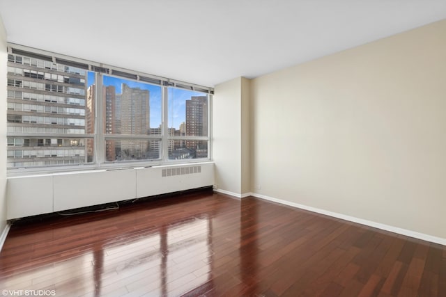 empty room with radiator heating unit and wood-type flooring