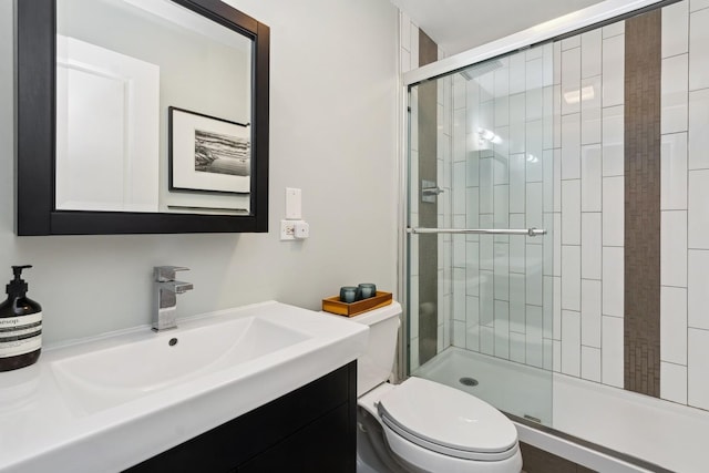 bathroom with vanity, toilet, and a shower with shower door