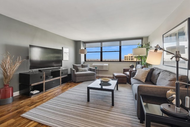 living room featuring hardwood / wood-style floors and a wall unit AC