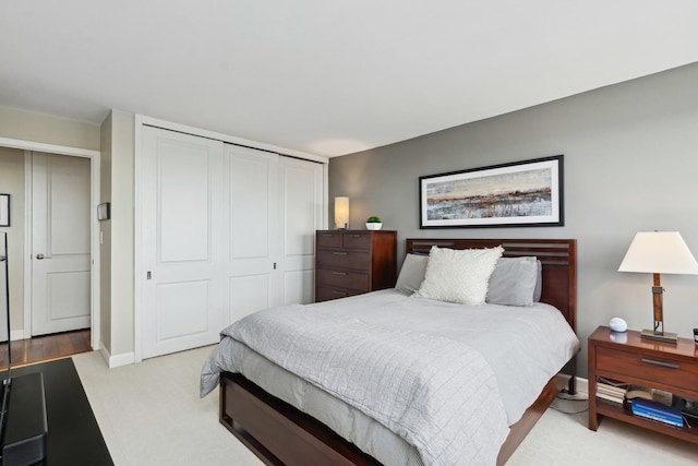 bedroom with light carpet and a closet