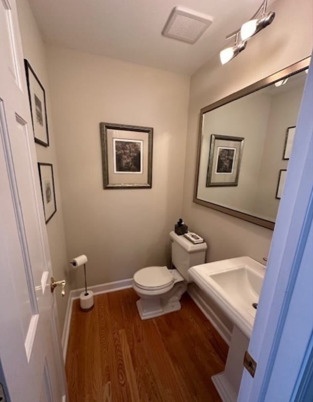 bathroom with hardwood / wood-style flooring and toilet