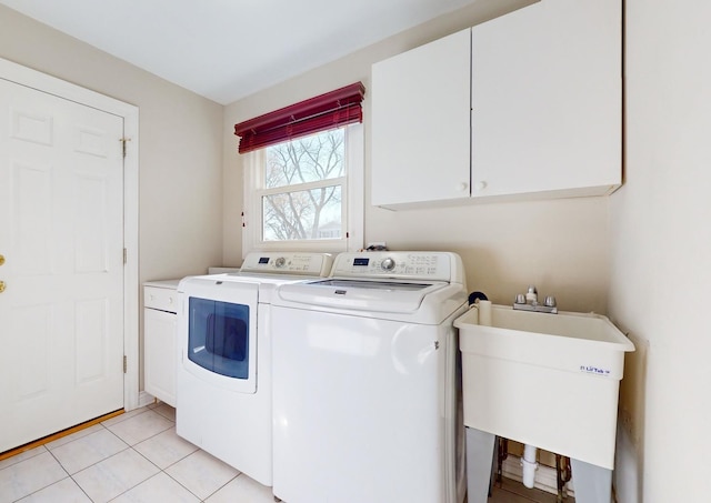 laundry room featuring sink, washing machine and dryer, cabinets, and light tile patterned flooring