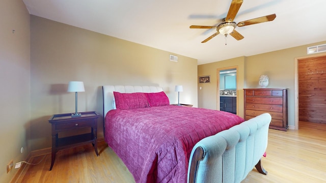 bedroom with ceiling fan, ensuite bathroom, and light hardwood / wood-style floors