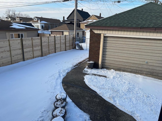 snowy yard featuring a garage