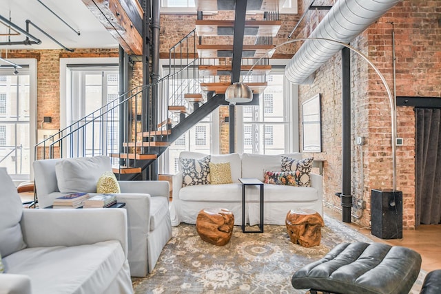 living room with brick wall and hardwood / wood-style floors