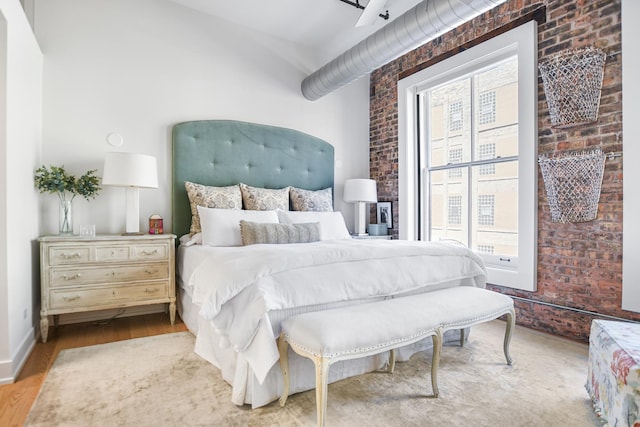 bedroom with brick wall and multiple windows