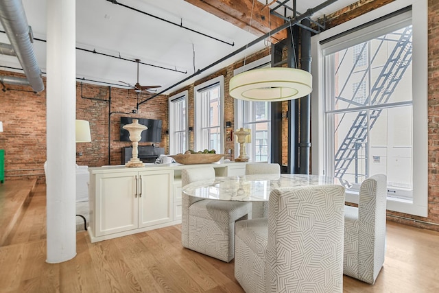 dining room featuring light hardwood / wood-style floors and brick wall