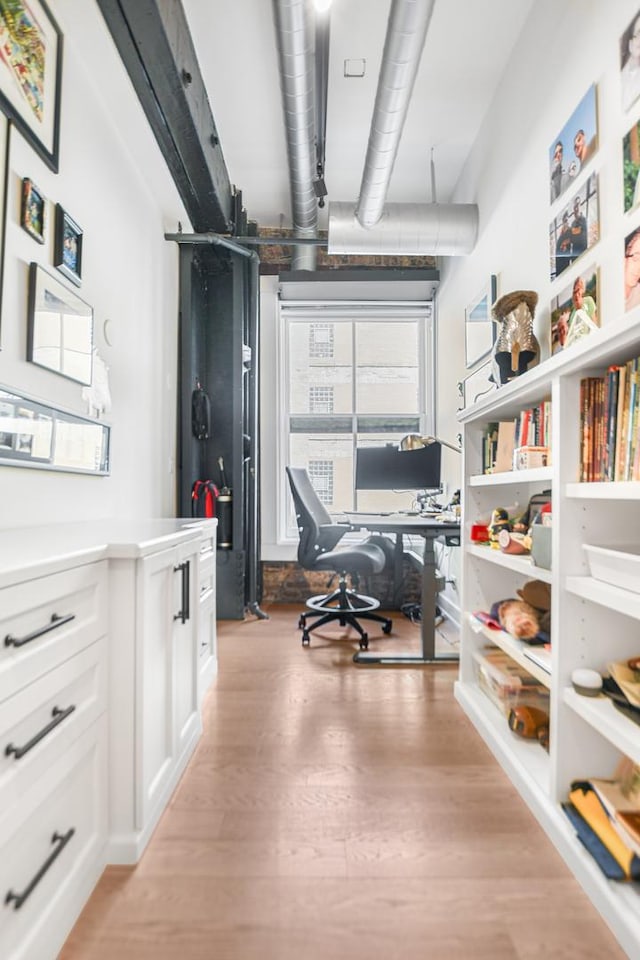 home office with light hardwood / wood-style floors