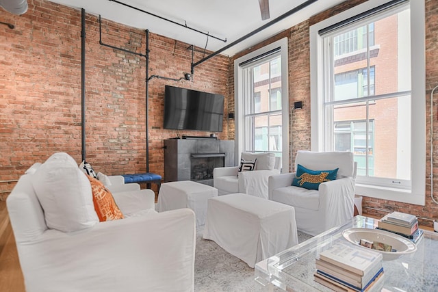 living room featuring brick wall and a healthy amount of sunlight