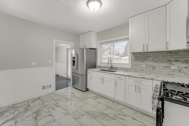 kitchen featuring stainless steel appliances, sink, and white cabinets