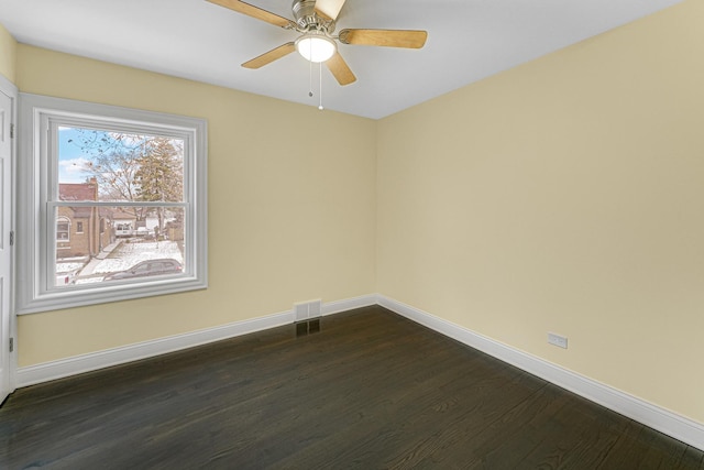 empty room featuring dark wood-type flooring and ceiling fan