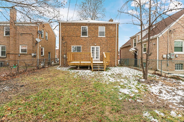 snow covered rear of property with a deck