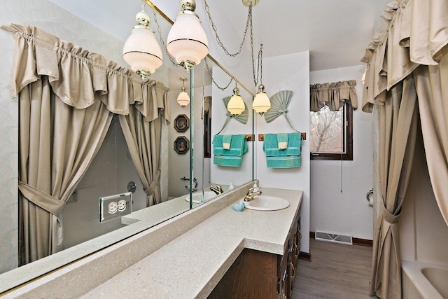 bathroom featuring vanity, wood-type flooring, and a washtub