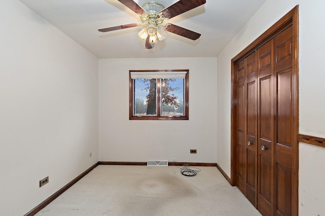 unfurnished bedroom with light carpet, ceiling fan, and a closet