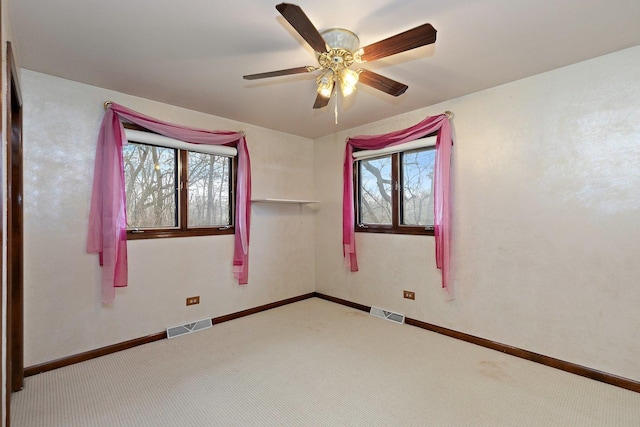 spare room featuring ceiling fan, carpet floors, and a healthy amount of sunlight