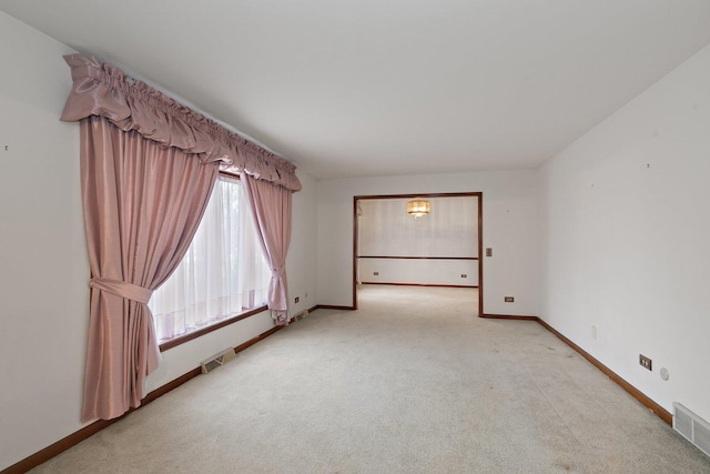 unfurnished room featuring light carpet