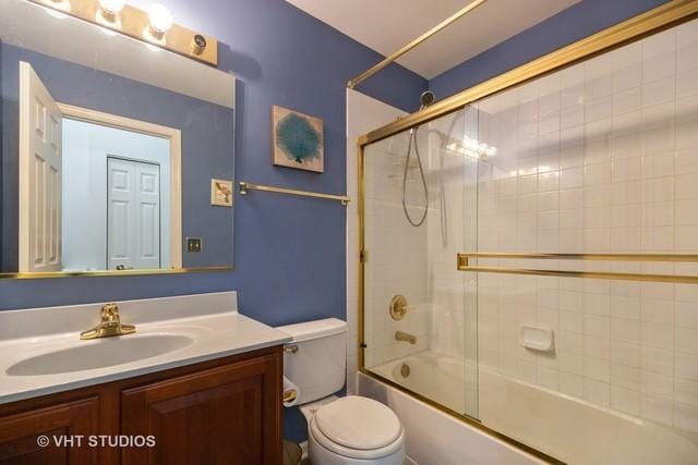 full bathroom featuring vanity, toilet, and combined bath / shower with glass door