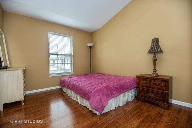 bedroom with dark hardwood / wood-style flooring and vaulted ceiling