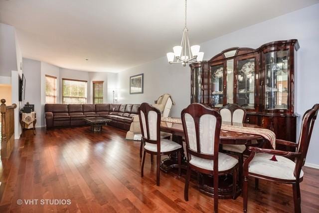 dining space with dark hardwood / wood-style flooring and a chandelier