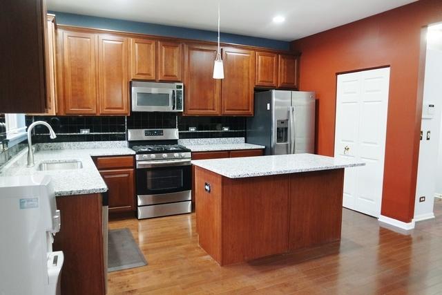 kitchen featuring a kitchen island, appliances with stainless steel finishes, tasteful backsplash, sink, and hanging light fixtures