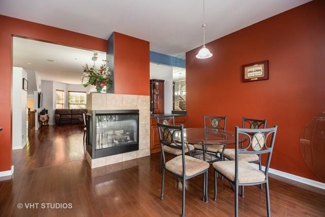 dining room with a fireplace and dark hardwood / wood-style floors