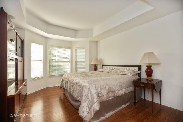 bedroom featuring dark hardwood / wood-style flooring and a tray ceiling