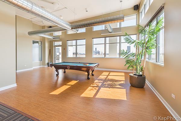 recreation room with hardwood / wood-style floors, pool table, and a towering ceiling