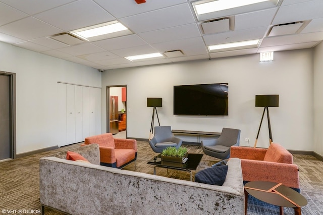 carpeted living room featuring a paneled ceiling