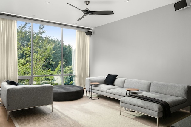 living room with expansive windows, carpet flooring, and ceiling fan