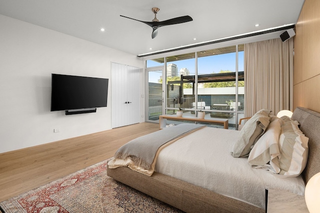 bedroom featuring access to exterior, hardwood / wood-style flooring, floor to ceiling windows, and ceiling fan