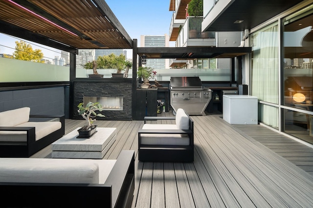 wooden deck with area for grilling, grilling area, and an outdoor living space with a fireplace