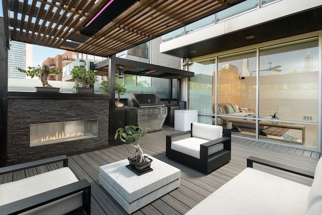 deck featuring exterior kitchen, grilling area, an outdoor living space with a fireplace, and a pergola