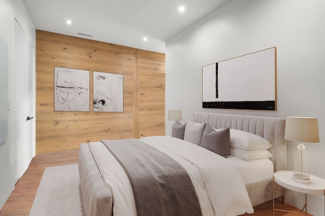 bedroom with wood-type flooring and wood walls