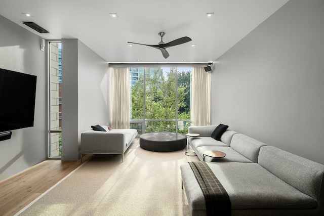 interior space featuring ceiling fan, hardwood / wood-style floors, and a wall of windows