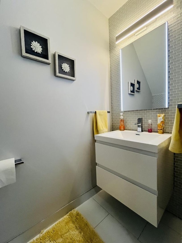 bathroom featuring lofted ceiling, vanity, tile patterned flooring, and backsplash