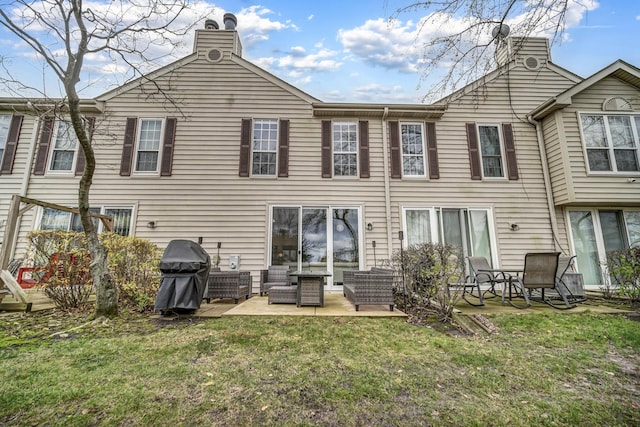 back of house featuring a patio area and a lawn