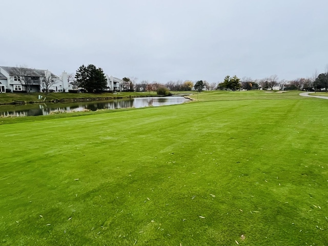 view of home's community with a lawn and a water view