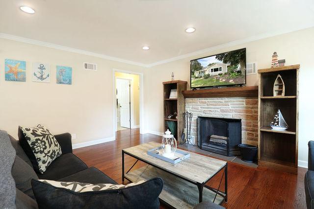 living room featuring a fireplace, ornamental molding, and dark hardwood / wood-style flooring