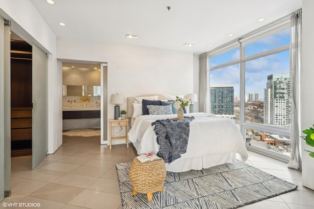 bedroom featuring light tile patterned flooring and connected bathroom